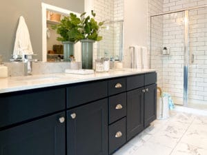 A dual vanity with black cabinets and white tile